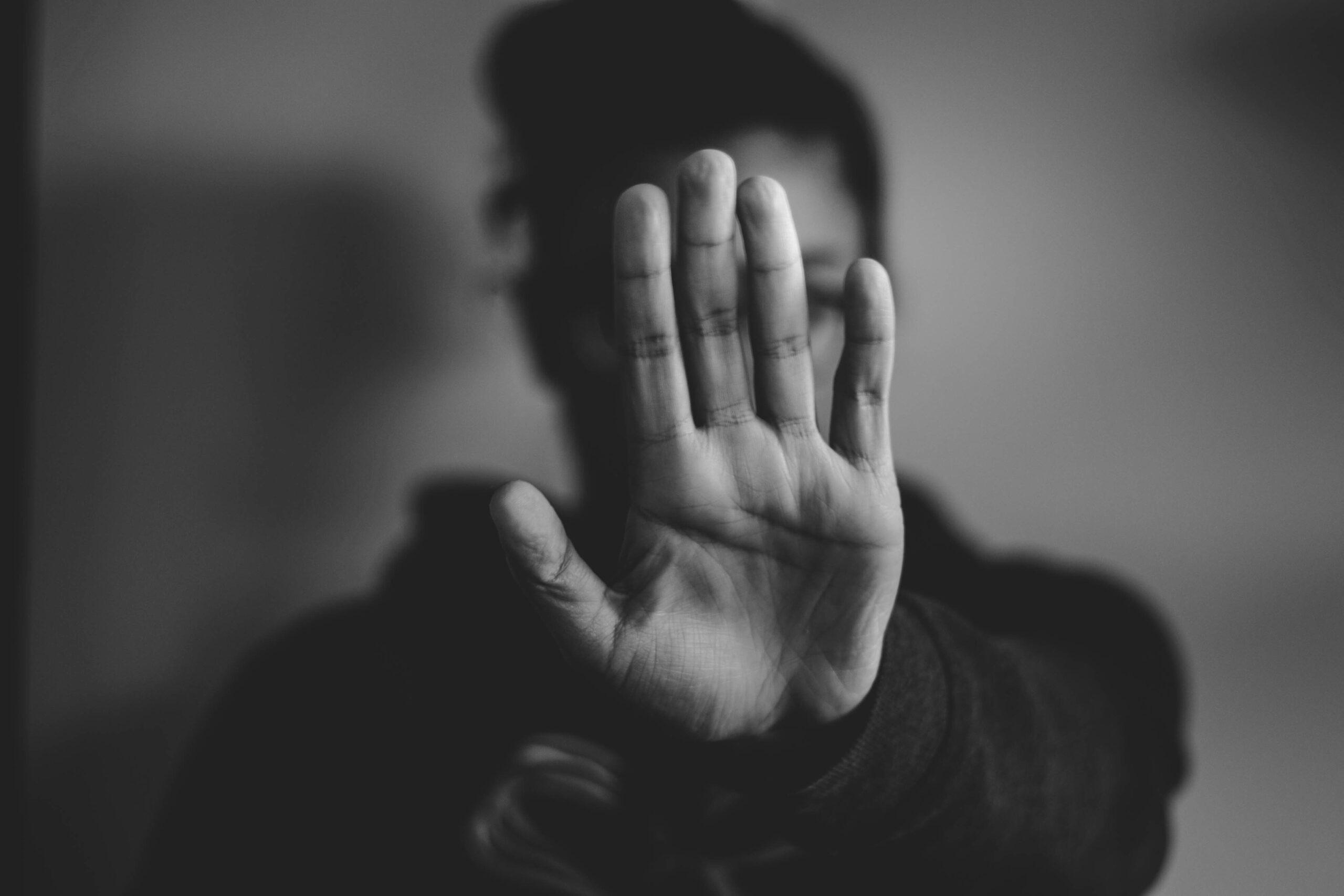 Personne tendant la main ouverte vers l’objectif en signe de refus