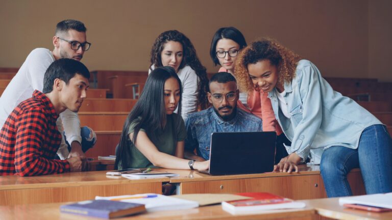 Un groupe de jeunes regarde un écran d’ordinateur ensemble